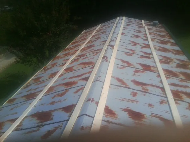 Rusted metal roof panels with new wood purlins before replacement — Storm Damage Roof Repair in Luckey by Roofing Brothers