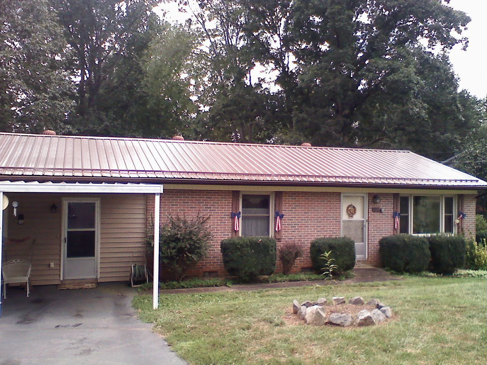 Bronze metal roof and carport on a brick ranch home — Roof Repair work by our crew in Luckey